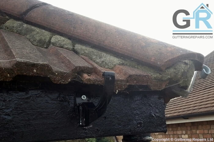 Roof gutter cleaning and repairs on a semi detached house roof.