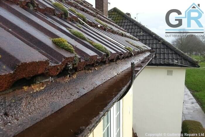 Cast iron roof gutter cleaning and repairs on a end of terrace home.