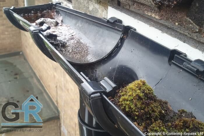 Gutter repair on a terraced house roof.